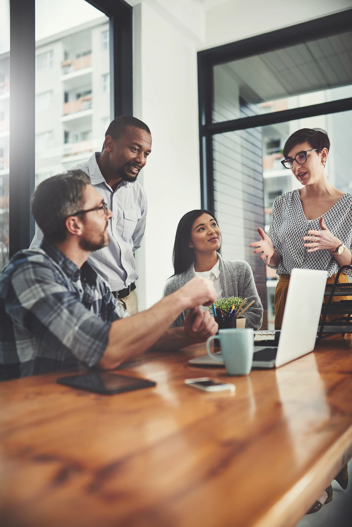 Colleagues collaborating around a table in a bright meeting room
