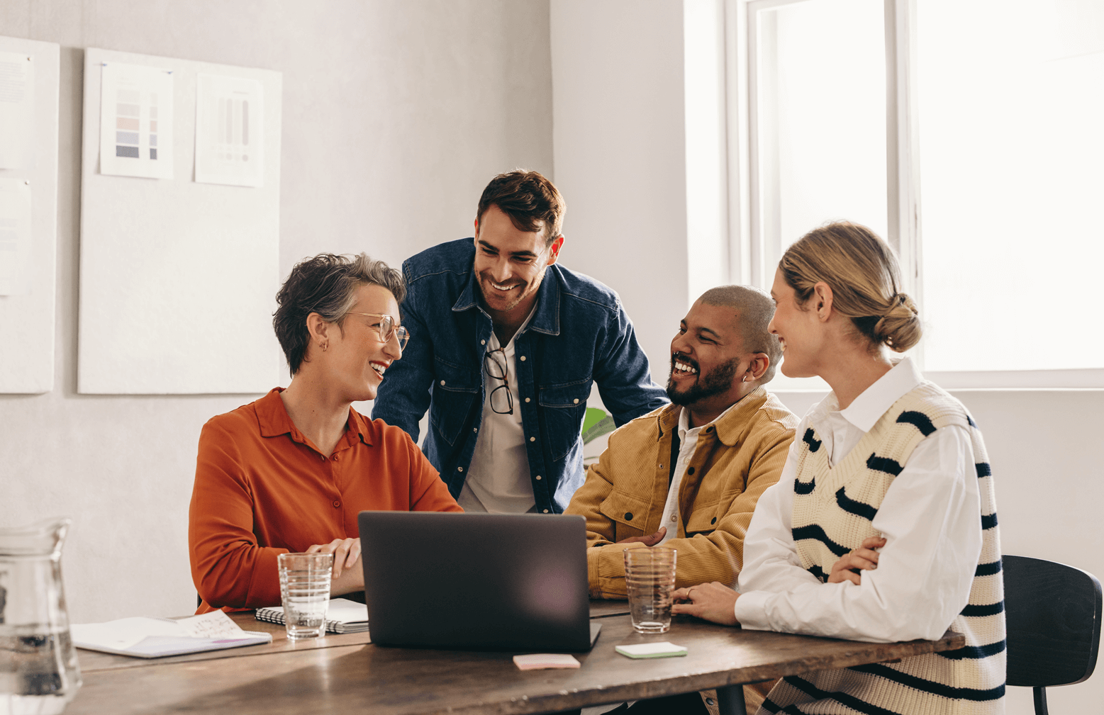 Team of people having a discussion in front of a laptop
