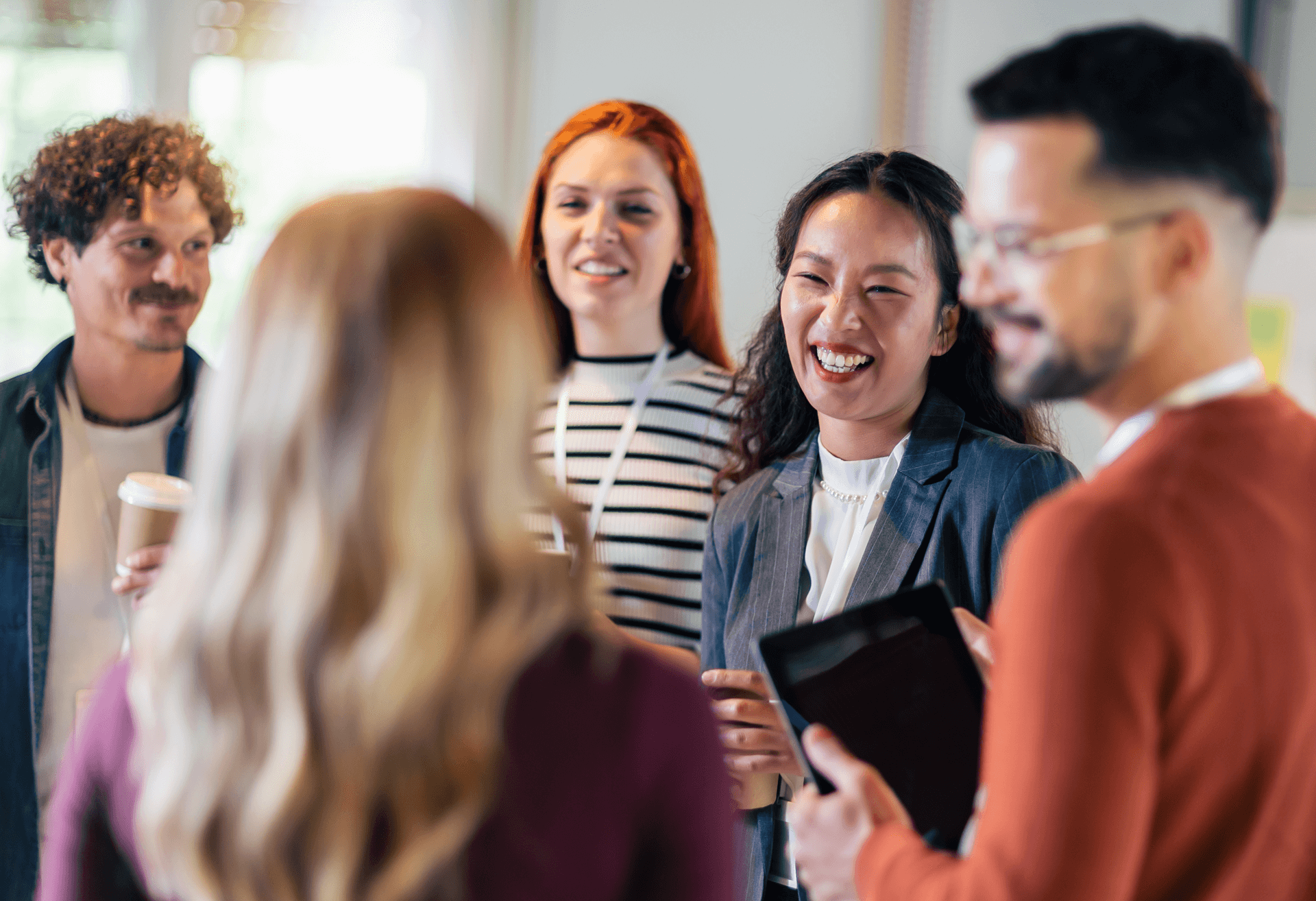 A group of co-workers standing and talking to each other