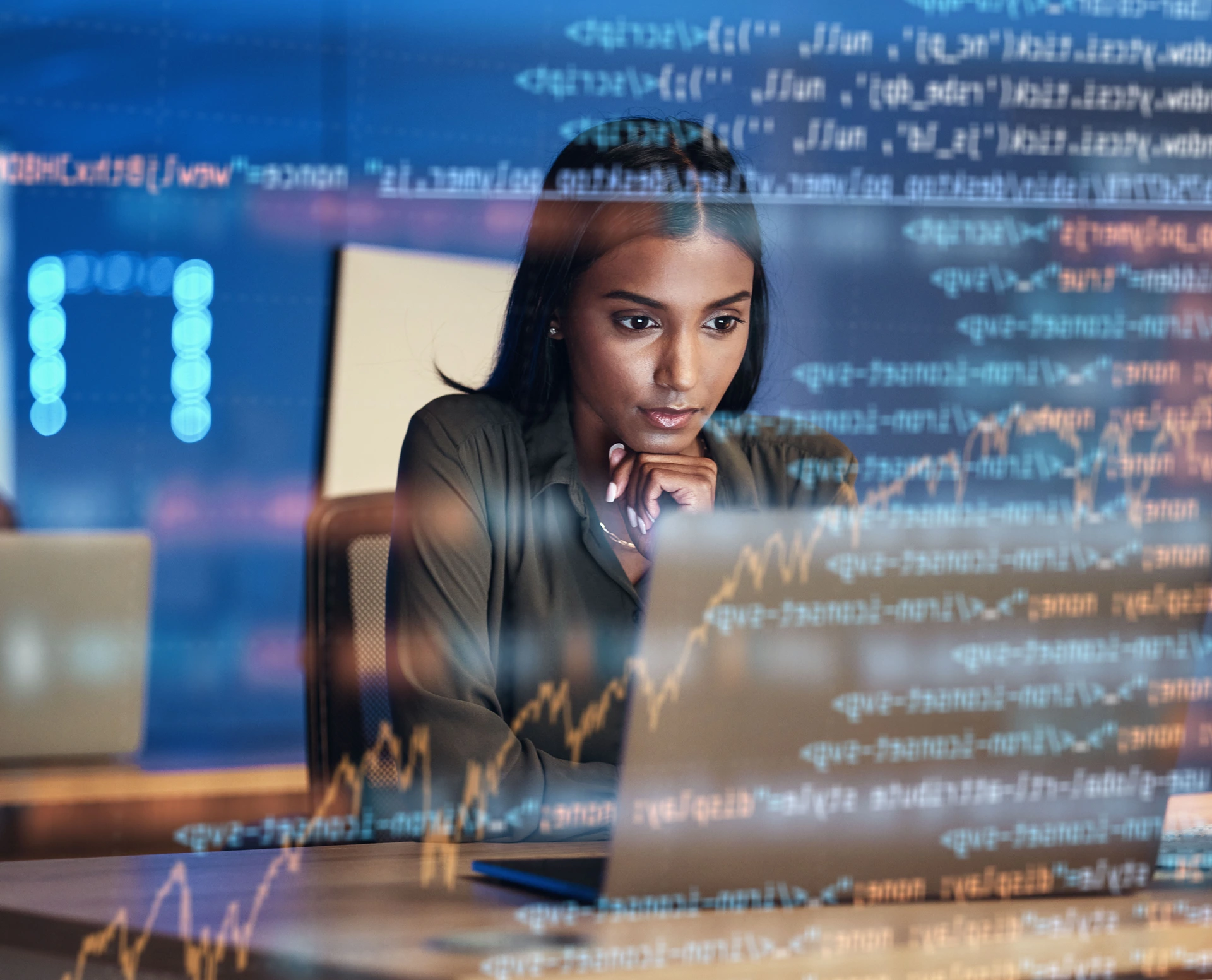 Woman looking at laptop with code in the foreground